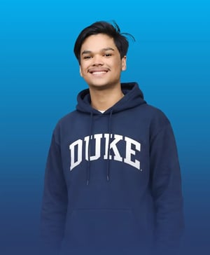 Smiling student wearing a navy blue Duke University hoodie against a blue background.