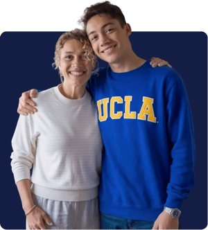A mother celebrating with her son, wearing a UCLA sweatshirt, after his college acceptance